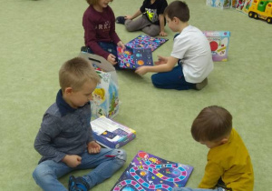 Dzieci grają w grę planszową na dywanie